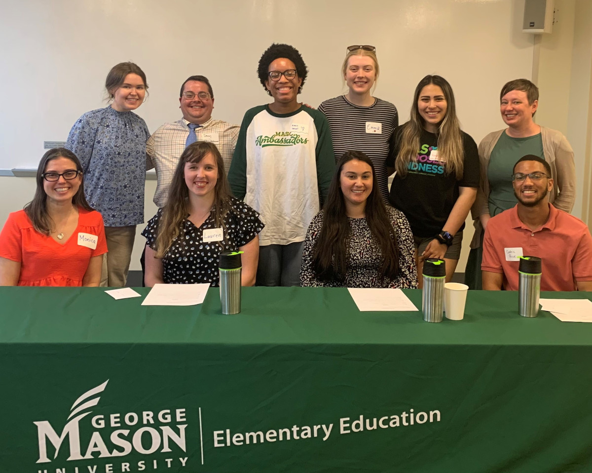 Photo of 10 people behind a table with a cover in front that reads George Mason University Elementary Education